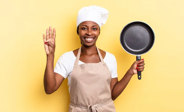 검은아 요리사 여성은 웃으며 보이며 앞으로 번째를 줍니다 — 스톡 사진