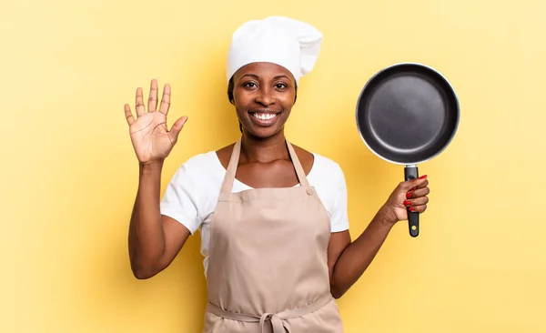 검은아 요리사 여성은 웃으며 보이며 앞으로 번째를 고개를 숙이고 있습니다 — 스톡 사진
