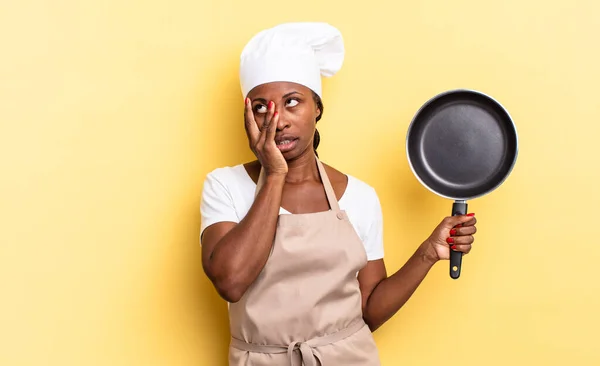 black afro chef woman feeling bored, frustrated and sleepy after a tiresome, dull and tedious task, holding face with hand