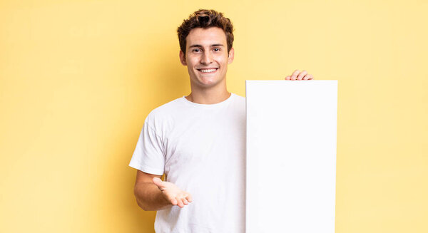 smiling happily with friendly, confident, positive look, offering and showing an object or concept. empty canvas concept