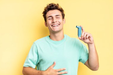 Komik bir şakaya yüksek sesle gülerek, mutlu ve neşeli hissederek, eğlenerek. astım konsepti