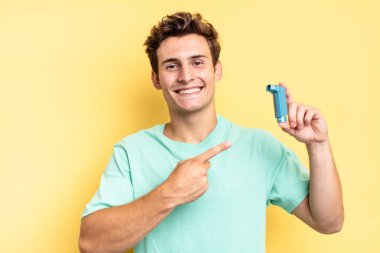 Neşeli bir şekilde gülümseyen, mutlu hisseden, kenarı ve yukarıyı gösteren, fotokopi uzayındaki nesneleri gösteren. astım konsepti