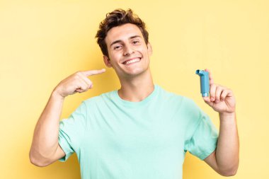 Kendi geniş gülüşüne, pozitif, rahat, tatmin olmuş tavrına güvenerek gülümsüyor. astım konsepti