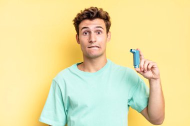 Şaşırmış ve kafası karışmış görünüyor, sinirsel bir hareketle dudağını ısırıyor, sorunun cevabını bilmiyor. astım konsepti