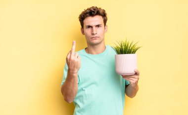 Öfkeli, sinirli, asi ve agresif hissederek, orta parmağını sallayarak, karşılık vererek. dekoratif bitki konsepti