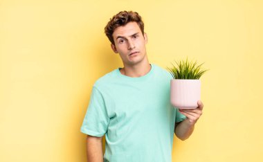 feeling puzzled and confused, with a dumb, stunned expression looking at something unexpected. decorative plant concept