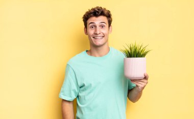 Mutlu ve hoş bir şekilde şaşırmış görünüyor, büyülenmiş ve şok olmuş bir ifadeyle heyecanlanıyor. dekoratif bitki konsepti