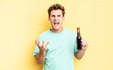 Kızgın, sinirli ve hayal kırıklığına uğramış görünüyorsun. Ne ya da neyin var diye bağırıyorsun. bira şişesi konsepti 