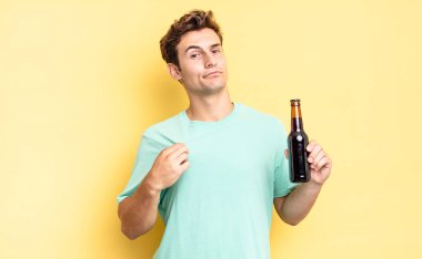 Kibirli, başarılı, pozitif ve gururlu görünüyor, kendini işaret ediyor. bira şişesi konsepti