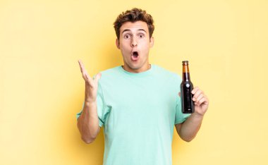 Son derece şok olmuş ve şaşırmış, endişeli ve paniklemiş hissediyorum, stresli ve dehşete düşmüş bir bakışla. bira şişesi konsepti