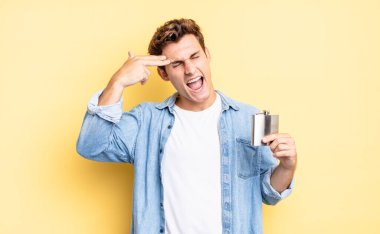 Mutsuz ve stresli görünüyor, intihar jesti elle silah işareti yapıyor, kafasını işaret ediyor. alkol şişesi konsepti