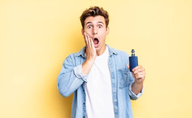 Şok olmuş ve korkmuş hissediyorum, ağzı açık ve elleri yanaklarında korkmuş görünüyor. buharlaştırıcı kavramı