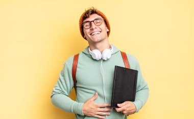 Komik bir şakaya yüksek sesle gülerek, mutlu ve neşeli hissederek, eğlenerek. öğrenci konsepti