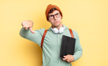 Kızgın, sinirli, hayal kırıklığına uğramış ya da hoşnutsuz, ciddi bir bakışla başparmaklarını aşağı gösteren. öğrenci konsepti