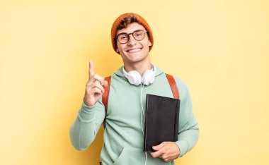 Gururla ve kendinden emin bir şekilde gülümseyerek bir numaralı pozu vererek, bir lider gibi hissederek. öğrenci konsepti