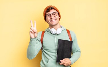 Gülümsüyor ve dost canlısı görünüyor. İki ya da iki numarayı gösteriyor. Elini ileri uzatıp geri sayıyor. öğrenci konsepti