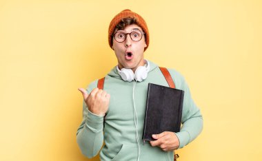 İnanamamaktan şaşkına dönmüş, yan taraftaki objeyi işaret edip 