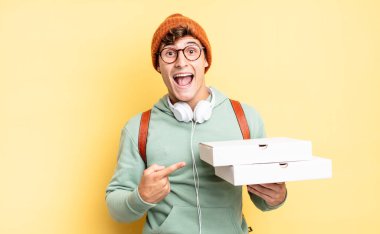 Heyecanlı ve şaşırmış görünüyor. Yana doğru ve yukarı doğru uzayı gösteriyor. Pizza konsepti