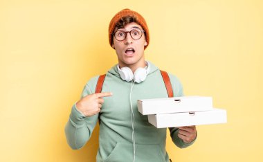 Şok olmuş ve ağzı açık, kendini işaret ederek şaşırmış görünüyordu. Pizza konsepti