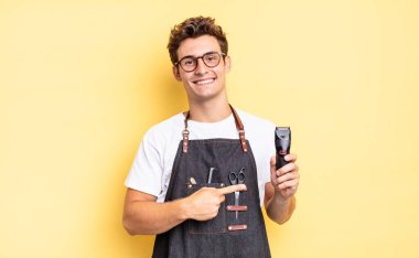 Neşeli bir şekilde gülümseyen, mutlu hisseden, kenarı ve yukarıyı gösteren, fotokopi uzayındaki nesneleri gösteren. berber konsepti