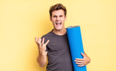 Kızgın, sinirli ve hayal kırıklığına uğramış görünüyorsun. Ne ya da neyin var diye bağırıyorsun. yoga mat konsepti 