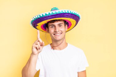 Gülümsüyor ve dost canlısı görünüyor, bir numara ya da ilk eli önde, geriye doğru sayıyor. Meksika şapkası konsepti
