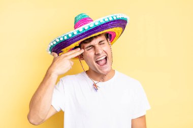 Mutsuz ve stresli görünüyor, intihar jesti elle silah işareti yapıyor, kafasını işaret ediyor. Meksika şapkası konsepti