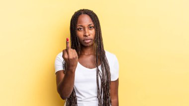 Afro siyah güzel kadın kızgın, sinirli, asi ve agresif hissediyor, orta parmağını sallıyor, karşı koyuyor.