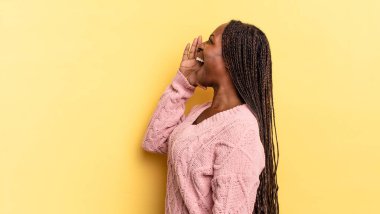Afro siyah güzel kadın profil görüntüsü, mutlu ve heyecanlı görünüyor, bağırıyor ve kenardaki boşluğu kopyalamak için arıyor