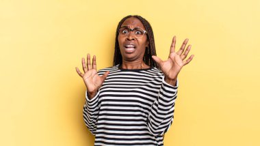 Afro siyah güzel kadın korkmuş hissediyor, geri çekiliyor ve korku ve panik içinde çığlık atıyor, kabusa tepki veriyor.