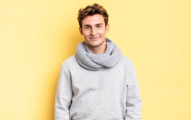 Genç bir delikanlı mutlu, mutlu ve mutlu görünüyor. Mutlu görünüyor.