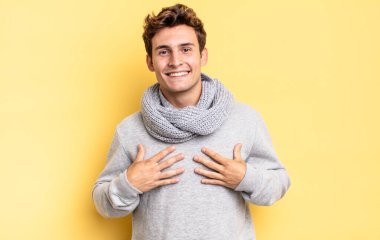 Genç çocuk mutlu görünüyor, şaşırmış, gururlu ve heyecanlı, kendini işaret ediyor.