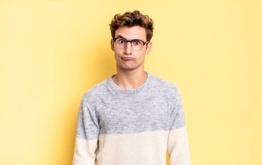 Genç çocuk kendini şaşkın ve kuşkulu hissediyor, merak ediyor ya da karar vermeye çalışıyor.