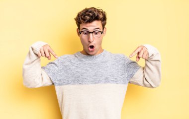 Delikanlı şokta, ağzı açık ve şaşırmış hissediyor. İnançsızlığa ve şaşkınlığa doğru bakıyor ve işaret ediyor.