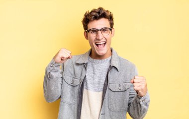 Genç çocuk mutlu, pozitif ve başarılı hissediyor, zaferi, başarıları ya da iyi şansı kutluyor.