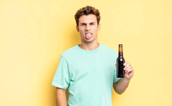 うんざりしていらいらして舌を出し何か嫌なことを嫌がる ビール瓶のコンセプト — ストック写真