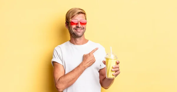 Blond Adult Man Smiling Cheerfully Feeling Happy Pointing Side Milkshake — Stock Photo, Image