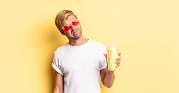 Sarışın Yetişkin Bir Adam Milkshake Ile Şaşkın Kafası Karışmış Hissediyor — Stok fotoğraf