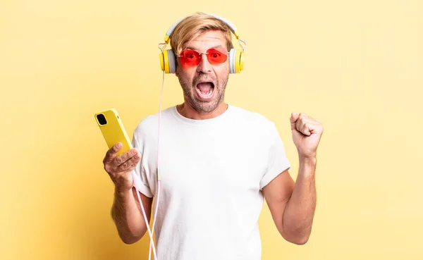 Hombre Adulto Rubio Sintiéndose Sorprendido Riendo Celebrando Éxito Con Auriculares —  Fotos de Stock