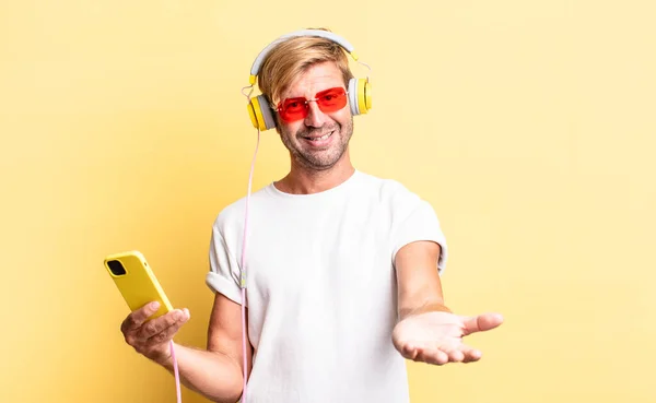 Blond Adult Man Smiling Happily Friendly Offering Showing Concept Headphones — Stock Photo, Image