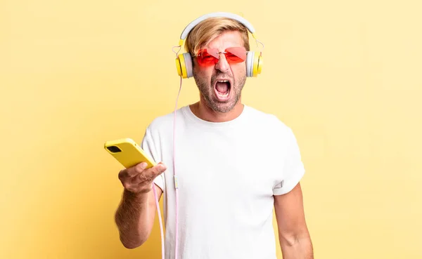 Hombre Adulto Rubio Gritando Agresivamente Mirando Muy Enojado Con Auriculares — Foto de Stock
