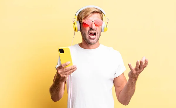 Blond Volwassen Man Zoek Boos Geïrriteerd Gefrustreerd Met Koptelefoon — Stockfoto