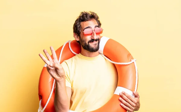 expressive crazy man smiling and looking friendly, showing number three. life guard concept