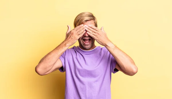 Bonito Loiro Adulto Homem Sorrindo Sentindo Feliz Cobrindo Olhos Com — Fotografia de Stock