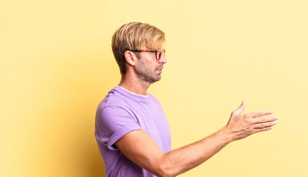 Knappe Blonde Volwassen Man Glimlachen Groeten Het Aanbieden Van Een — Stockfoto