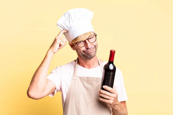 Sarışın Yakışıklı Yetişkin Bir Adam Elinde Bir Şişe Şarap Tutuyor — Stok fotoğraf