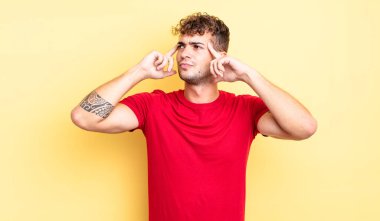 Genç ve yakışıklı bir adam kafası karışmış ya da şüphe içinde, bir fikre odaklanmış, çok düşünüyor, kenarda boşluğu kopyalamaya çalışıyor.