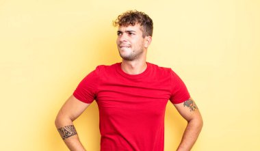 Genç yakışıklı adam şüphe ediyor ya da düşünüyor, dudağını ısırıyor ve kendini güvensiz ve gergin hissediyor, kenarda yer arıyor.