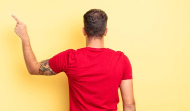 Genç yakışıklı adam dikiz aynası ve fotokopi alanı üzerinde duran ve objeyi işaret eden