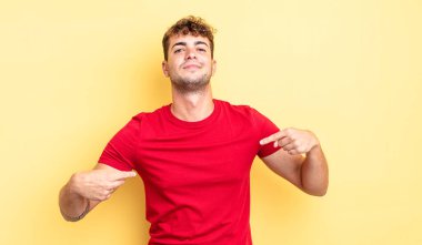 Genç yakışıklı adam gururlu, kibirli, mutlu, şaşırmış ve tatmin olmuş görünüyor, kendini gösteriyor, kazanan gibi hissediyor.